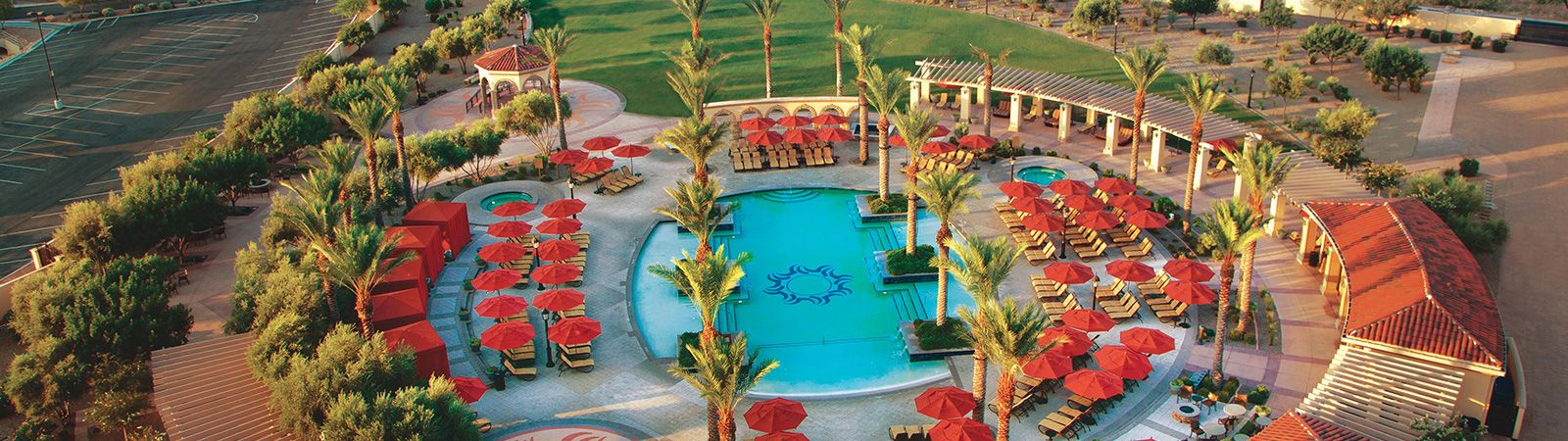 Aerial view of an outdoor pool with red umbrellas and lounge chairs